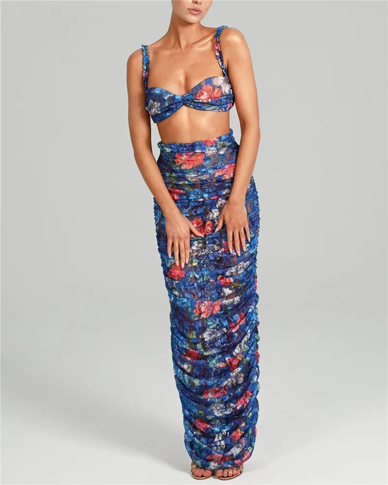 Robe fleurie chic longue sans manches pour soirée, couleur bleue avec détails rouges et verts, parfaite pour cocktail ou mariage.