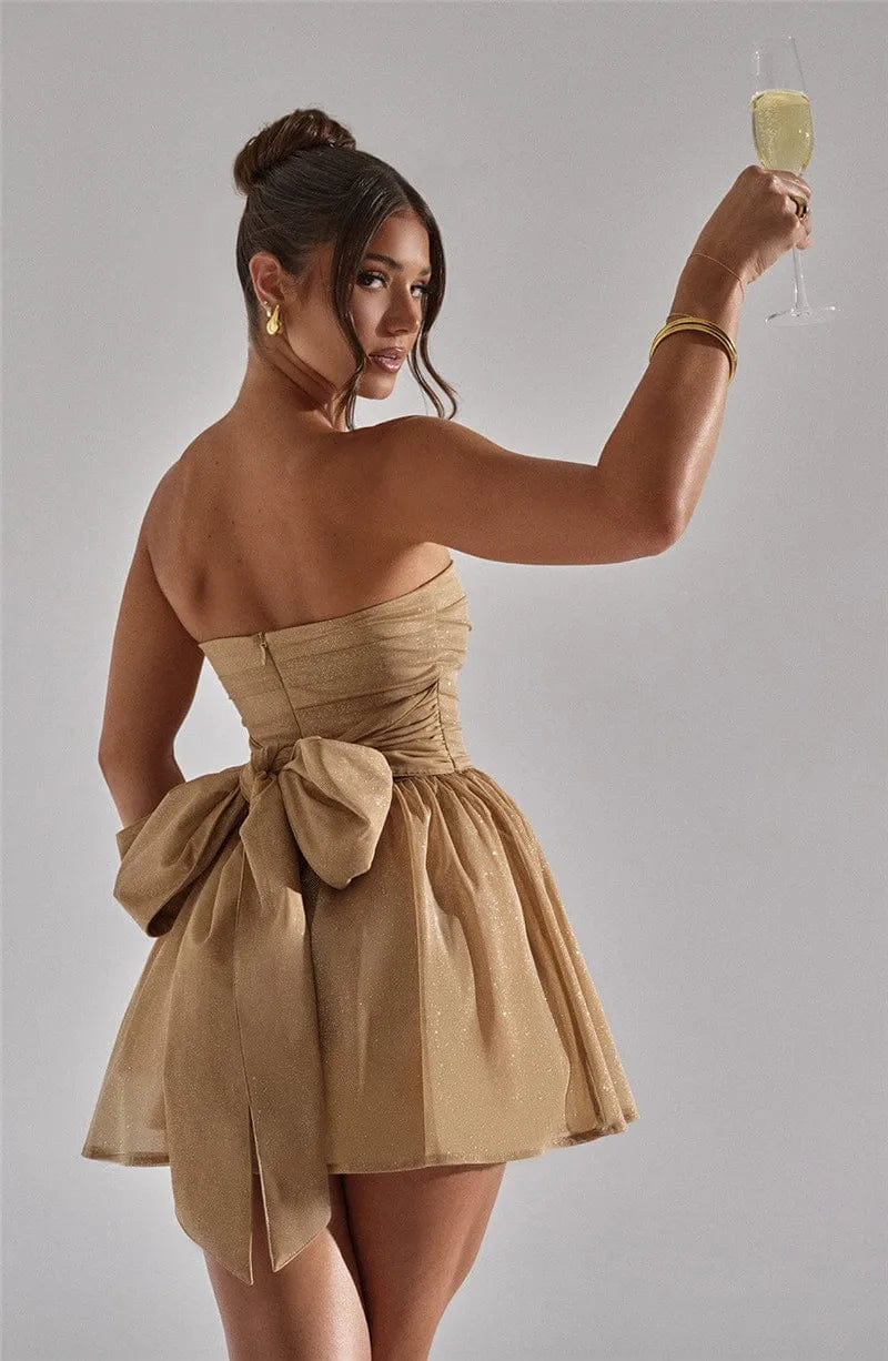Robe bustier courte dorée à paillette pour soirée cocktail, sans manches avec nœud, idéale pour évènement chic et élégant.