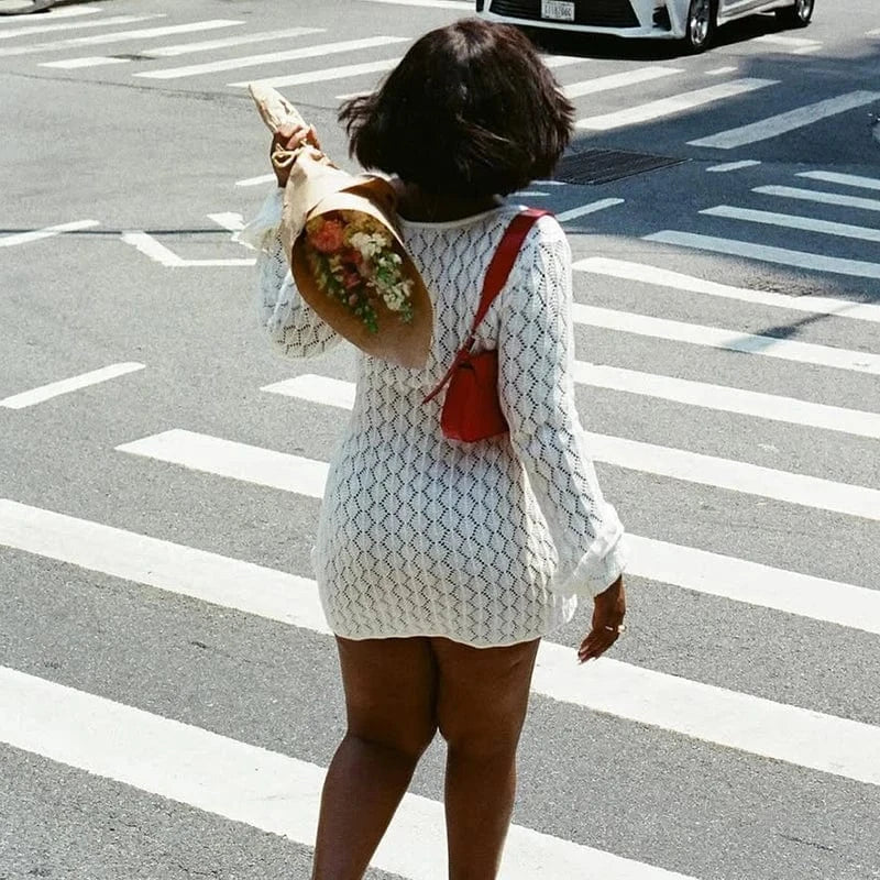 Robe courte blanche moulante manches longues en maille chic accessoire sac rouge idéale pour l’été en ville