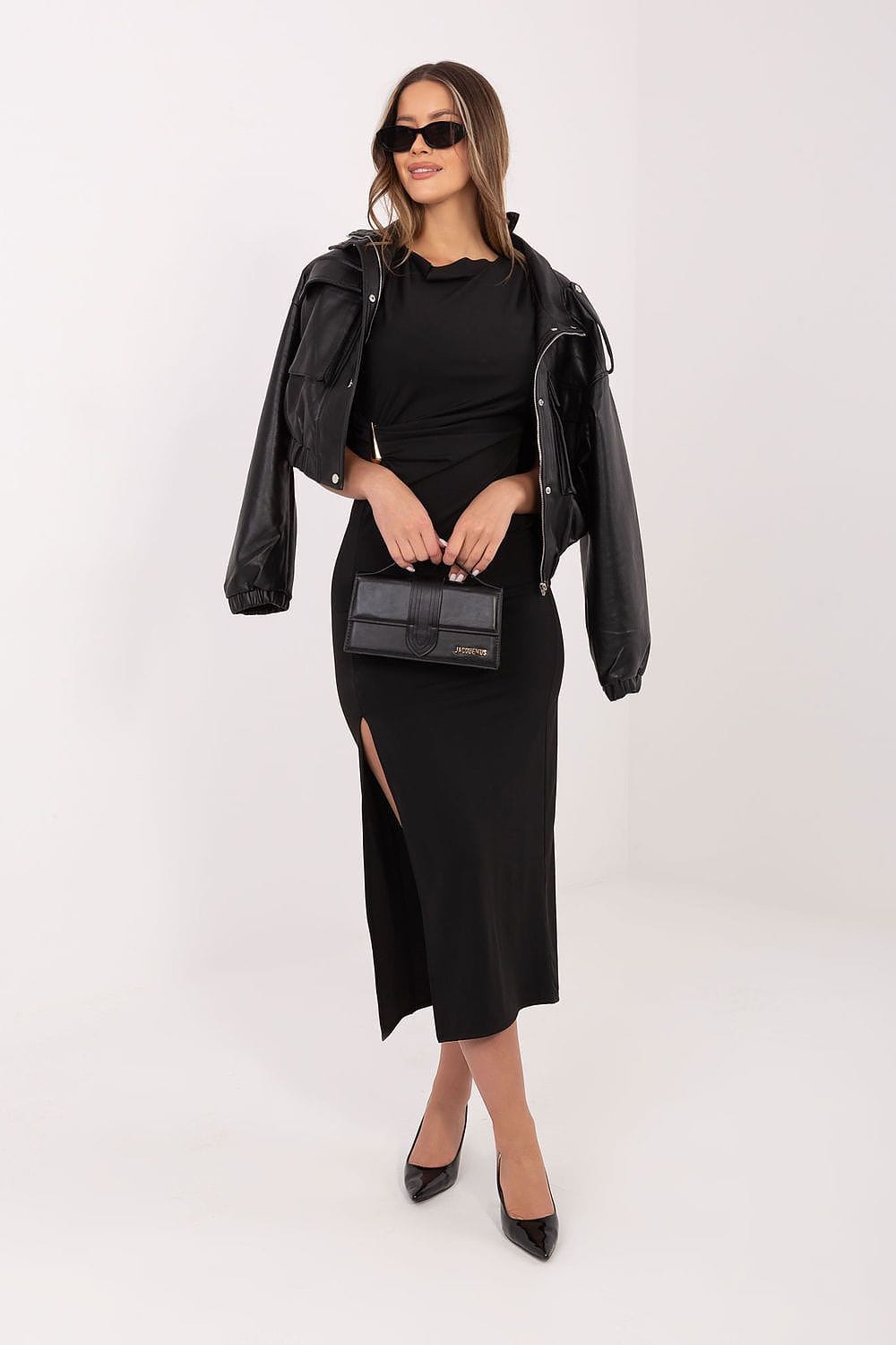 Robe de soirée chic noire longue fendue manches courtes, accessoirisée d’une veste en cuir et pochette élégante