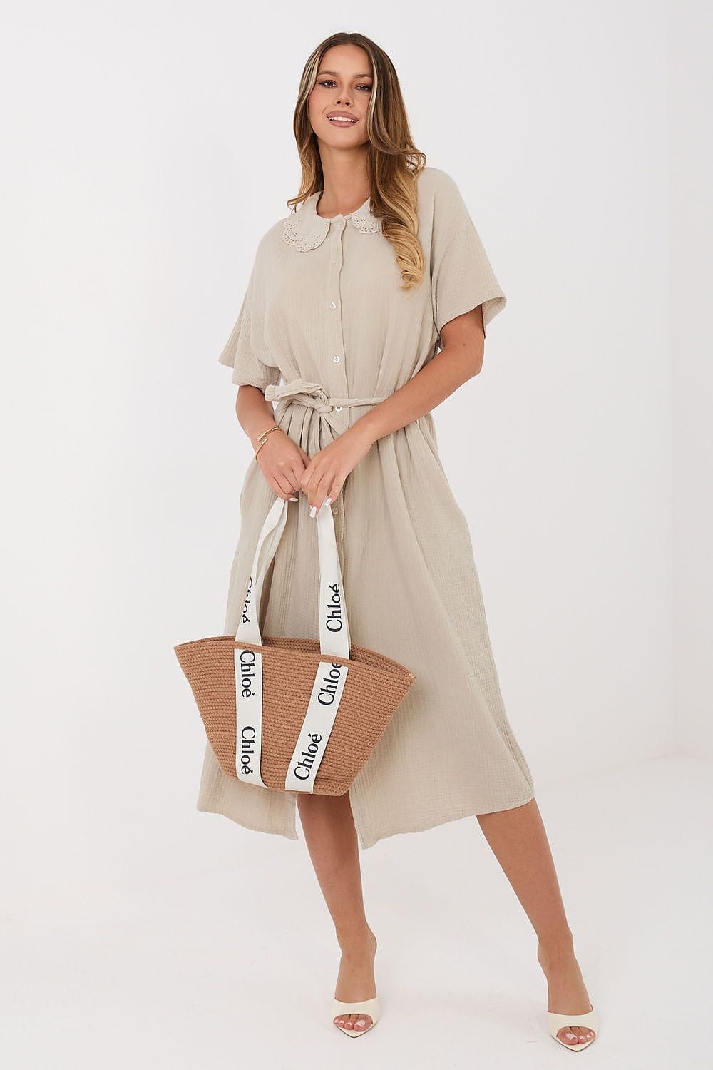 Robe midi casual beige en gaze de coton, manches courtes, portée avec un sac cabas en paille pour l’été