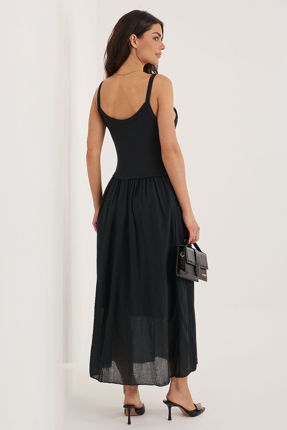 Robe longue noire dos nu soirée chic fluide femme avec petite pochette noire, idéale évènement habillé