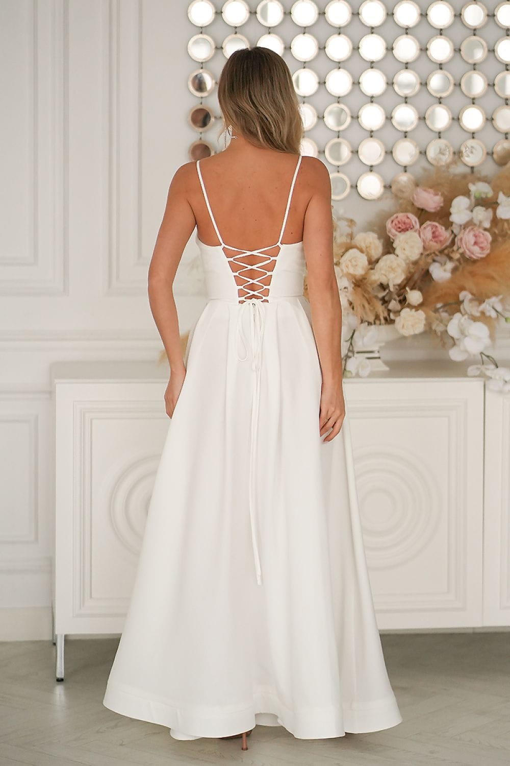 Robe longue blanche dos nu pour mariage invitée chic avec bretelles fines et laçage élégant au dos