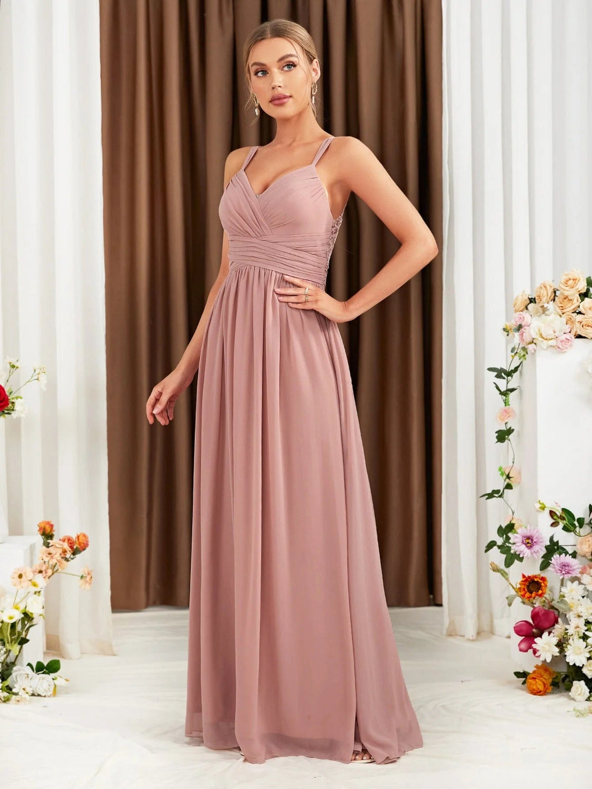 Robe demoiselle d'honneur rose poudré longue dos nu pour mariage, silhouette princesse avec manches fines et détails drapés.