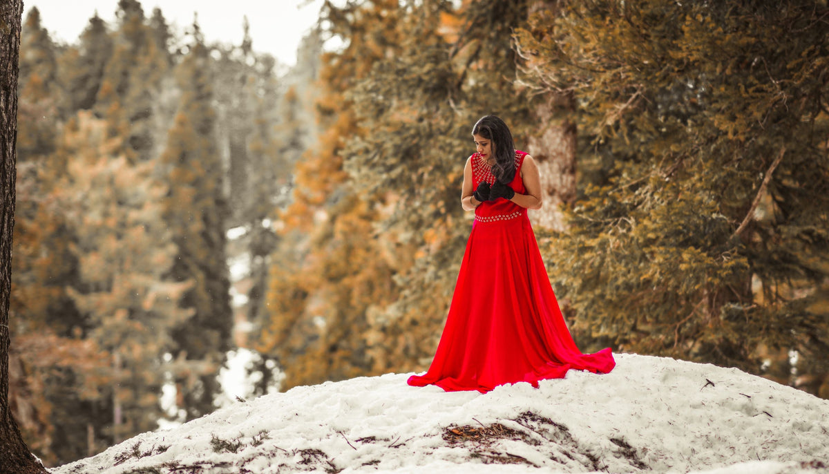 femme en robe rouge sur une colline en hiver 