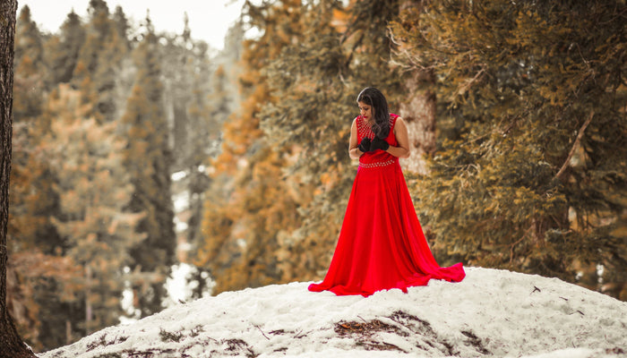 femme en robe rouge sur une colline en hiver 