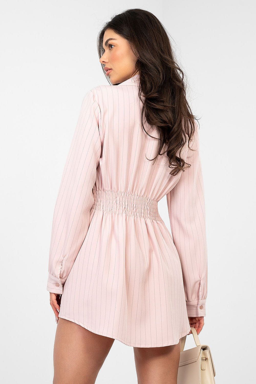 Robe courte chemise rose à manches longues, rayée, style casual chic pour printemps ou été, accessoirisée d’un sac beige