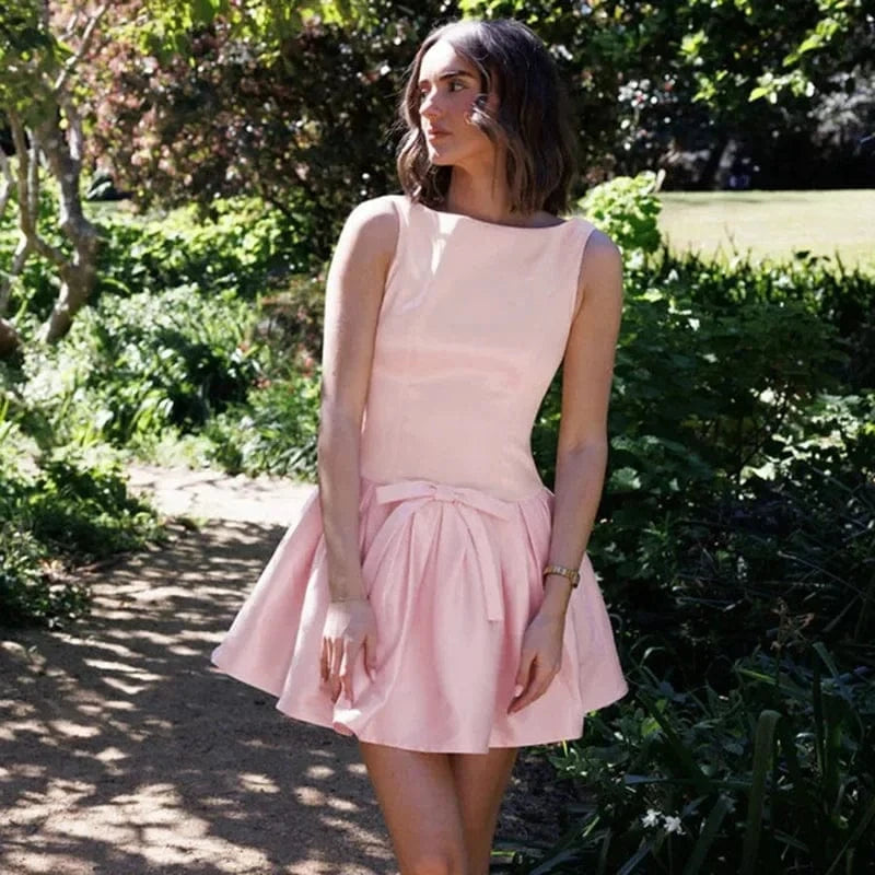 Robe courte rose cocktail chic évasée sans manches avec nœud élégante pour invitée été ou événement spécial