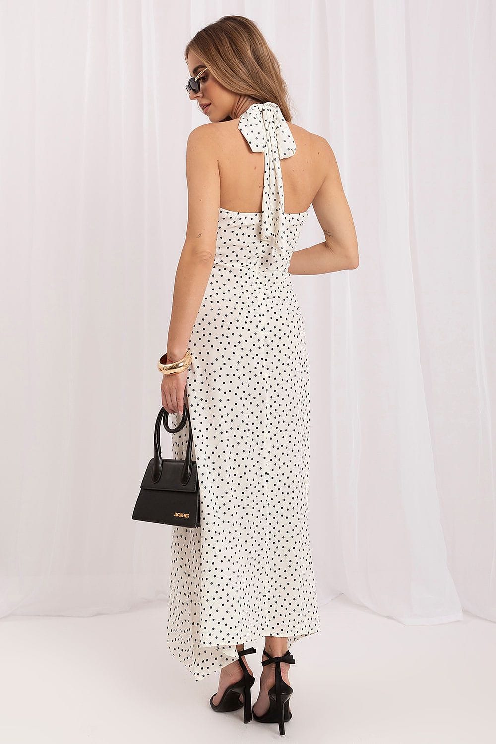 Robe longue blanche à pois noirs style été dos nu chic avec sac à main noir et sandales à talons