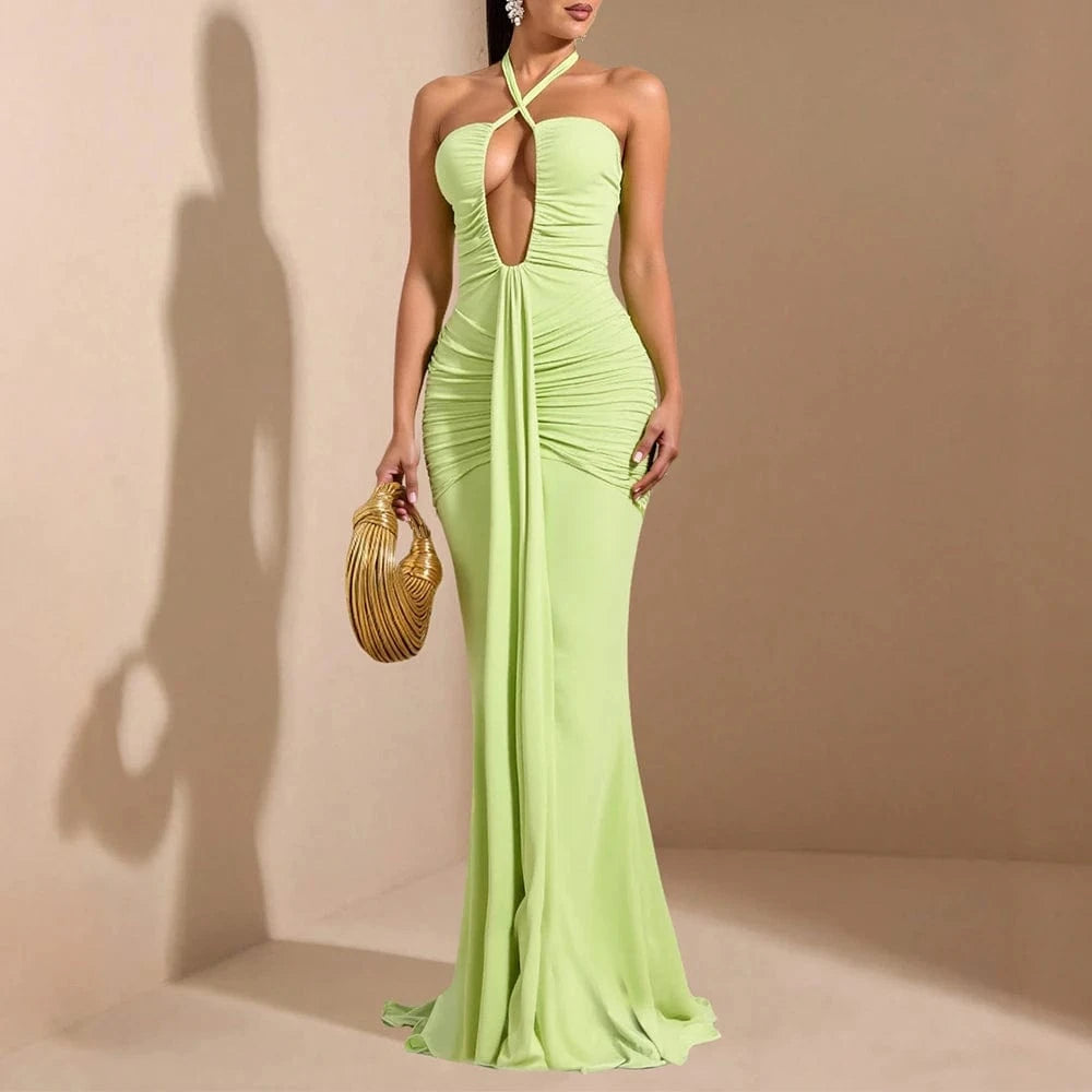 Robe de soirée sexy longue verte moulante dos nu avec décolleté fendu, accessoire sac doré élégant