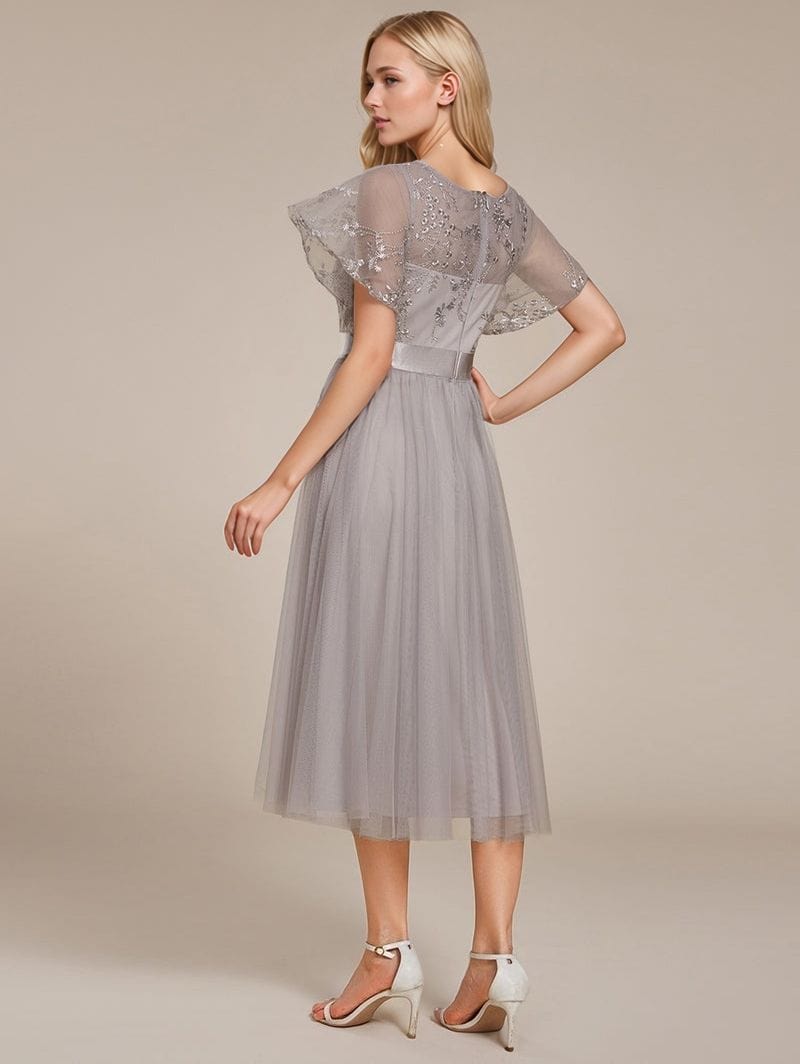 Robe de soirée chic grise en tulle longueur midi avec manches courtes volantées idéale pour un mariage élégant