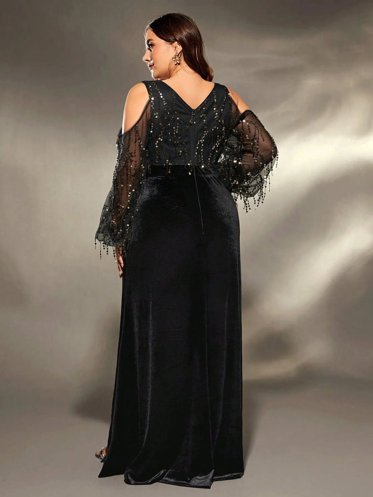 Robe de soirée grande taille noire, longue avec manches fendues pour un look élégant et chic.