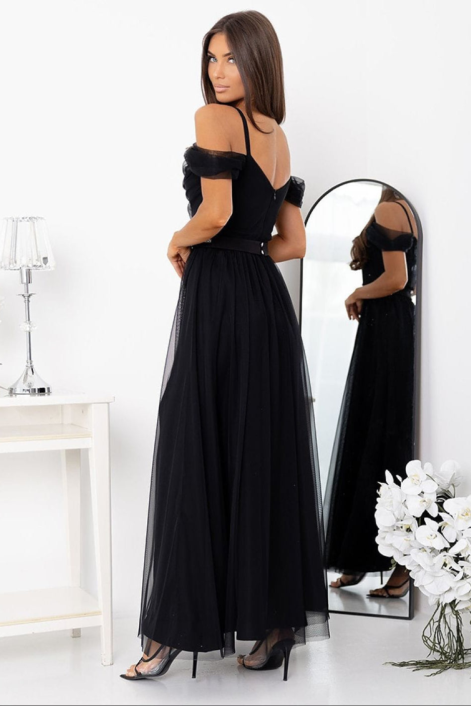 Robe longue noire soirée chic épaules dénudées dos nu fluide femme élégante mannequin devant miroir