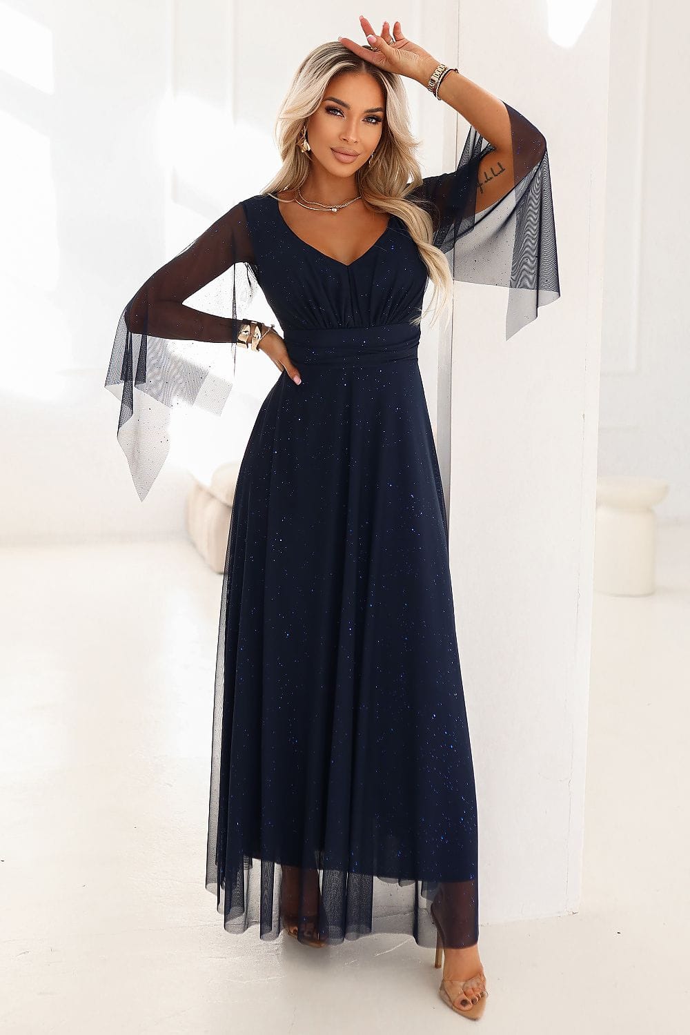 Robe de soirée chic longue noire évasée manches longues transparente décolleté glamour pour événement élégant