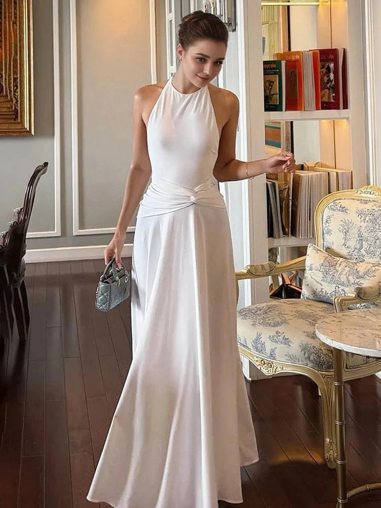 Robe longue blanche élégante soirée mariage invitée chic dos nu fluide accessoire sac à main élégant