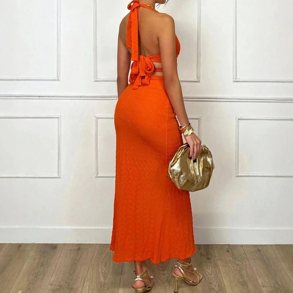Robe de soirée chic dos nu orange longue moulante accessoire pochette dorée parfaite pour événement élégant