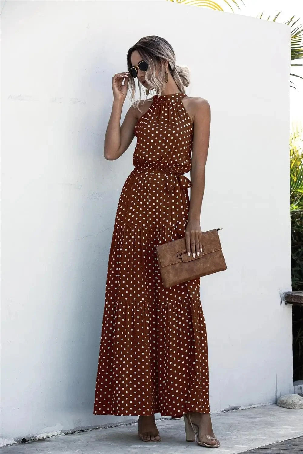 Robe été bohème longue marron à pois blancs sans manches, portée avec pochette et sandales, idéale plage