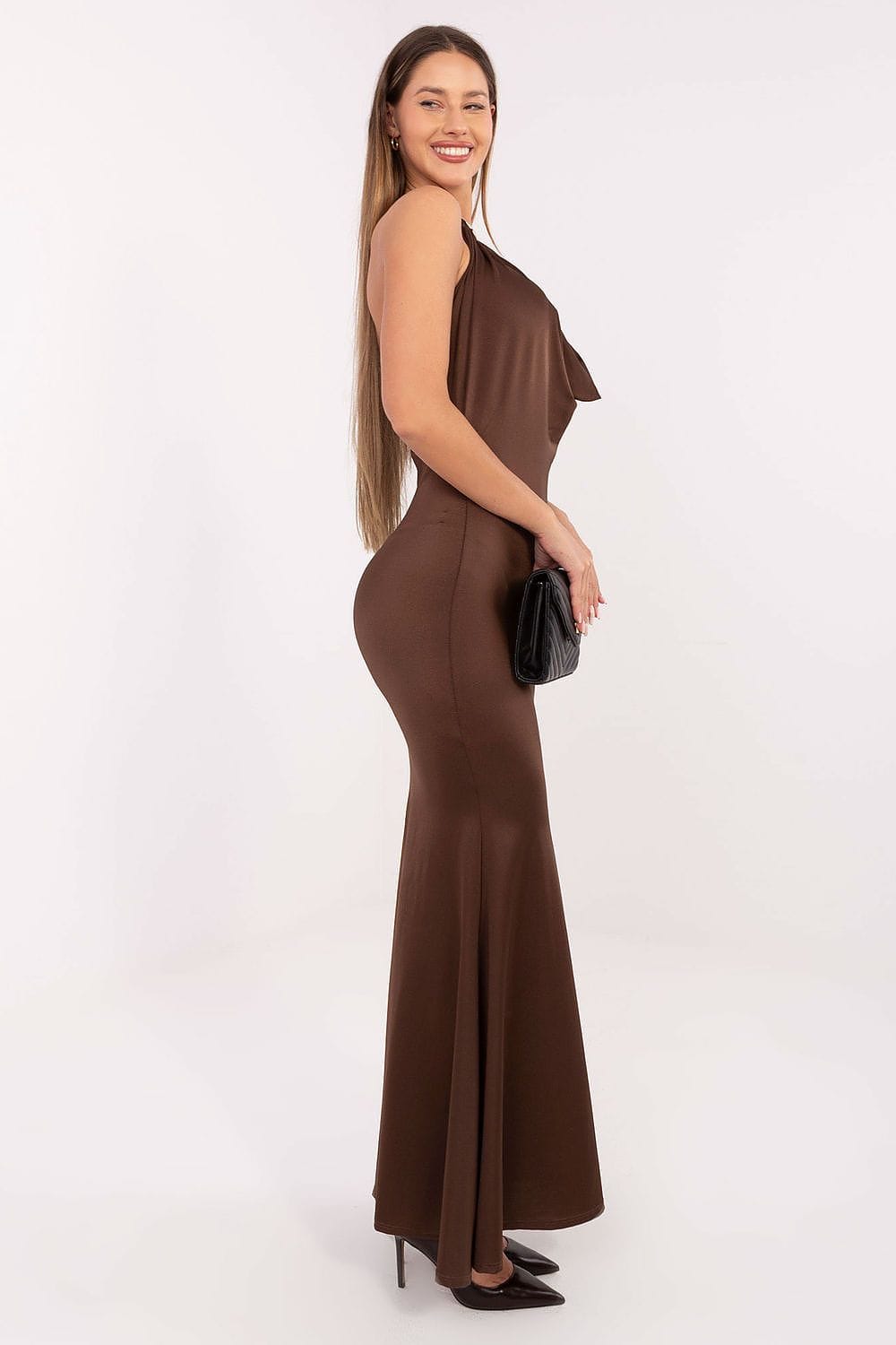Robe longue moulante marron soirée chic avec une manche sans manches, accessoirisée d’une pochette noire élégante
