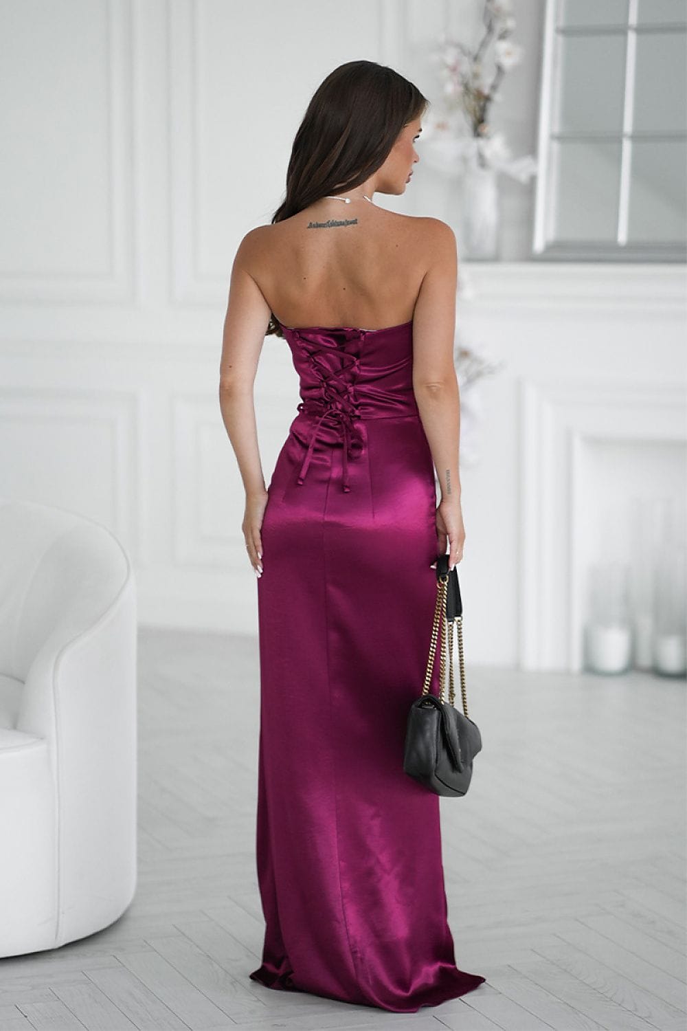 Robe longue soirée chic dos nu violette en satin avec sac noir chaîne dorée, idéale évènement habillé