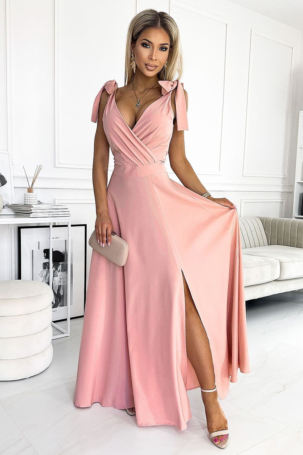 Robe de soirée rose longue fendue avec manches courtes et détails noeuds pour événement chic et élégant.