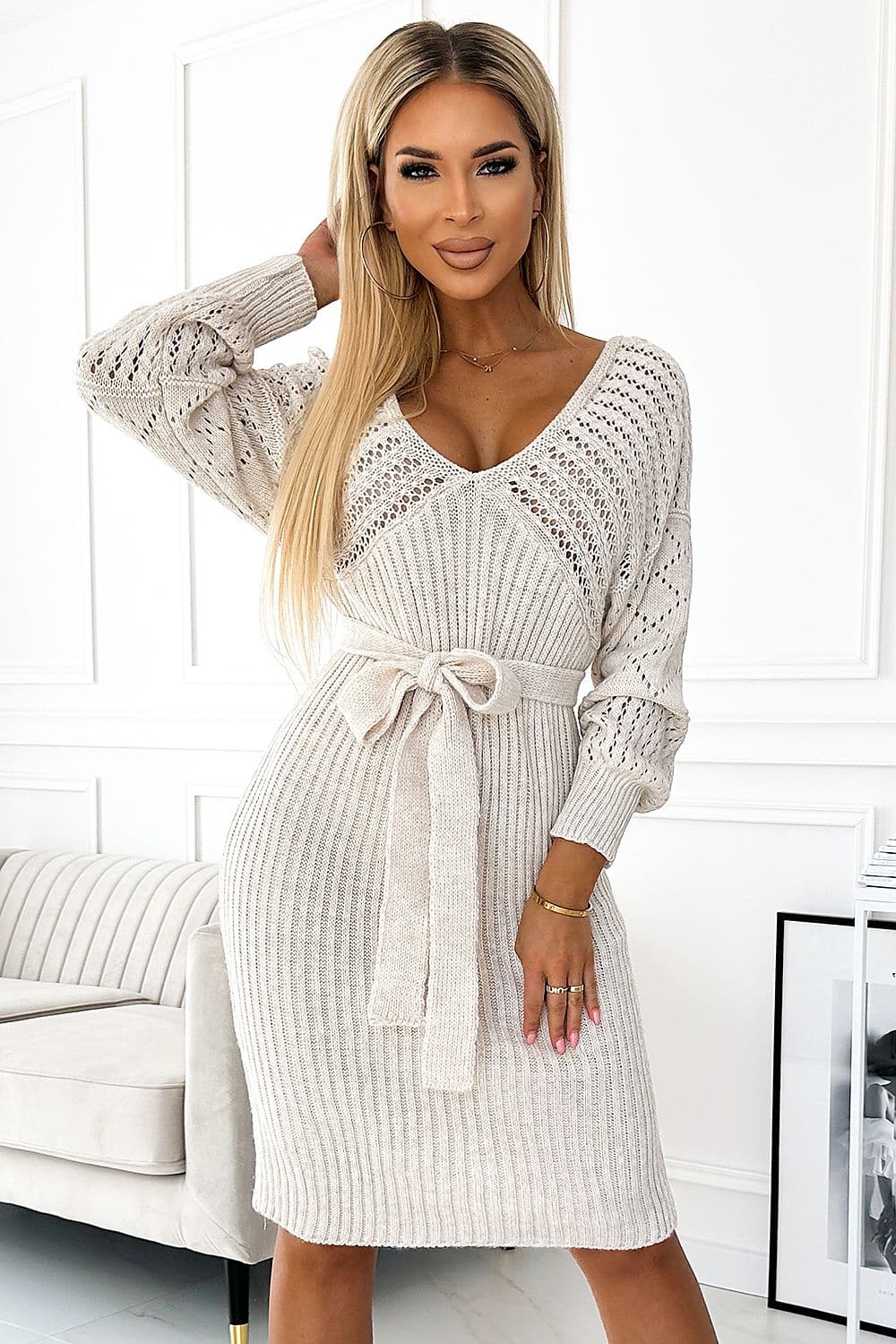 Robe pull beige en tricot à manches longues et col en V pour une tenue décontractée et chic, longueur midi et silhouette droite.